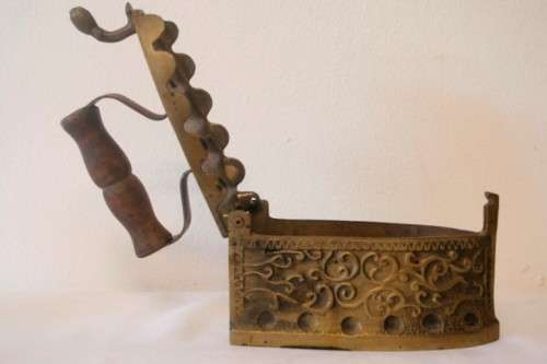 A fabulous very ornate antique brass sad iron/coal iron. Stunning as a display piece.