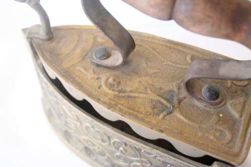 A fabulous very ornate antique brass sad iron/coal iron. Stunning as a display piece.