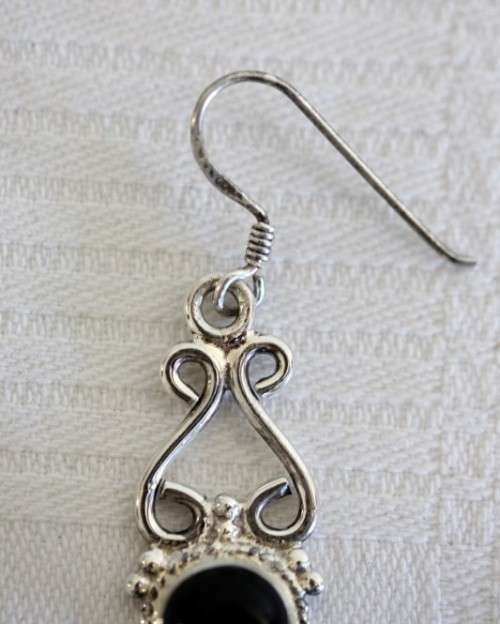 A beautiful sterling silver (925) earring set with round raised onyx stones and ornate detailing