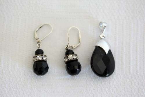 A gorgeous matching black stone and silver metal pendant and earring set with diamante