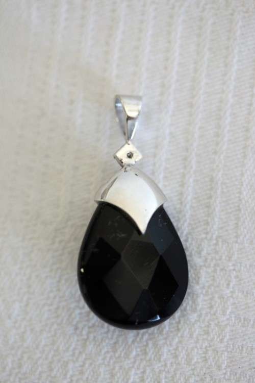 A gorgeous matching black stone and silver metal pendant and earring set with diamante