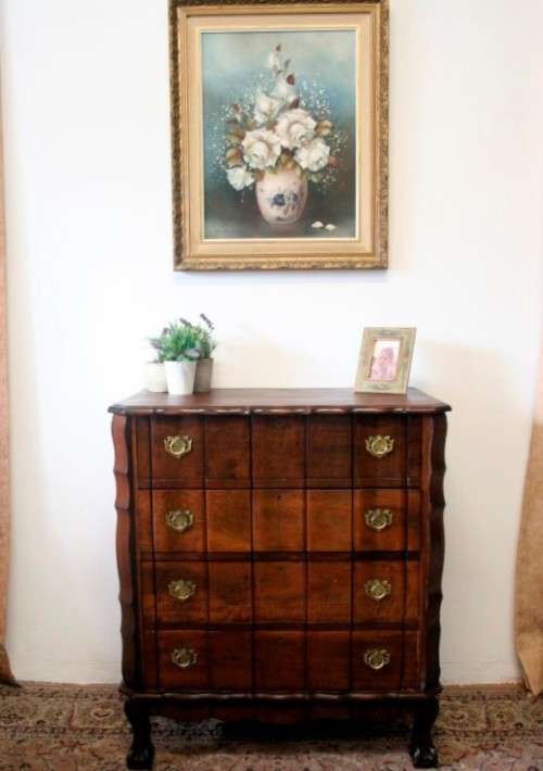 An exquisite vintage Imbuia 4-drawer chest of drawers with ornate handles and ample storage space