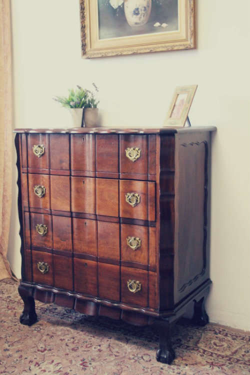An exquisite vintage Imbuia 4-drawer chest of drawers with ornate handles and ample storage space