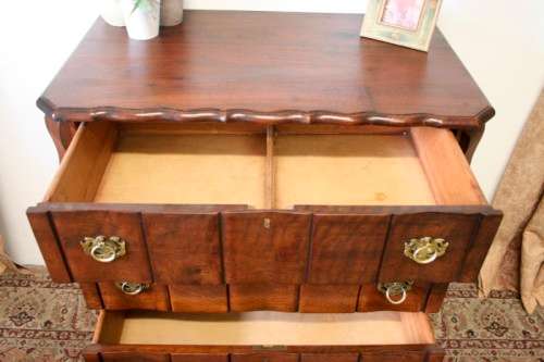 An exquisite vintage Imbuia 4-drawer chest of drawers with ornate handles and ample storage space