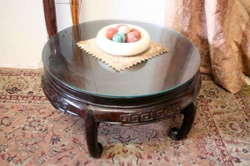 A superb round Chinese Ming style coffee table with carved detailing and glass top.