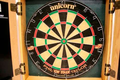 A top quality Unicorn (Phil Taylor)dart board in a wooden cabinet w score boards in super condition.