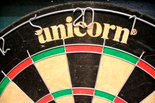 A top quality Unicorn (Phil Taylor)dart board in a wooden cabinet w score boards in super condition.