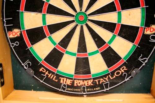 A top quality Unicorn (Phil Taylor)dart board in a wooden cabinet w score boards in super condition.