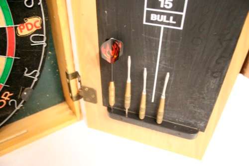 A top quality Unicorn (Phil Taylor)dart board in a wooden cabinet w score boards in super condition.