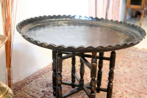 A fabulous Moroccan etched copper tray (w a paint technique) folding table with a wood base.