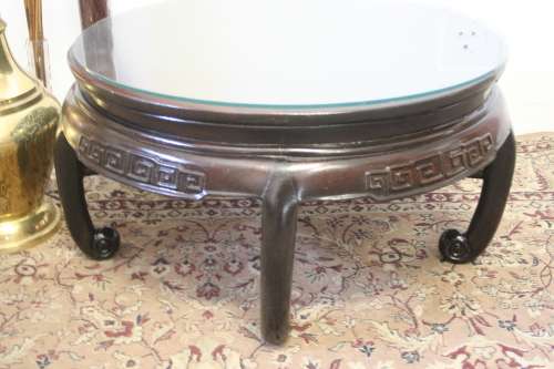 A superb round Chinese Ming style coffee table with carved detailing and glass top.