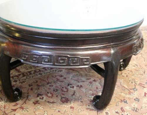 A superb round Chinese Ming style coffee table with carved detailing and glass top.