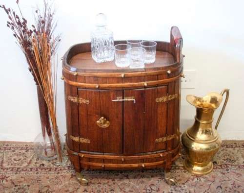 A unique antique Oak drinks trolley cabinet with brass embellishments and original castors.