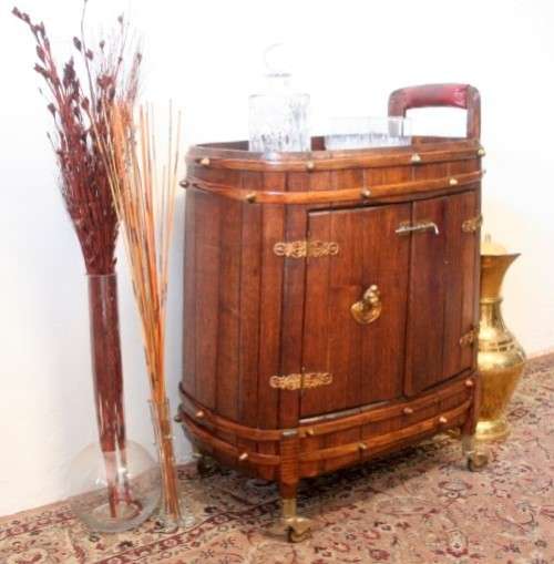 A unique antique Oak drinks trolley cabinet with brass embellishments and original castors.