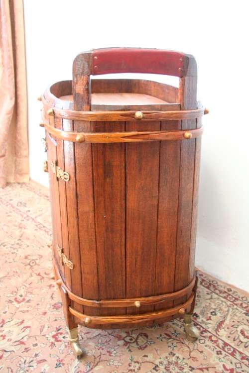 A unique antique Oak drinks trolley cabinet with brass embellishments and original castors.