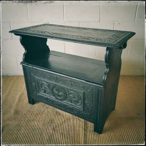 A superb antique hand-carved blackened oak monks bench with a storage chest in the base
