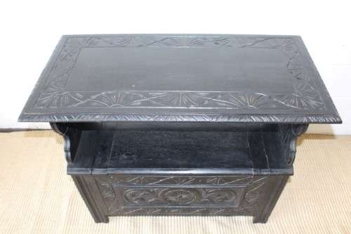A superb antique hand-carved blackened oak monks bench with a storage chest in the base