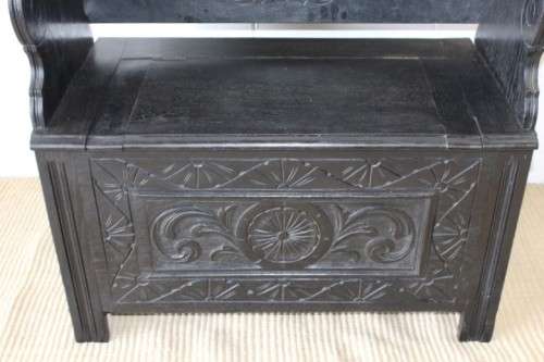 A superb antique hand-carved blackened oak monks bench with a storage chest in the base