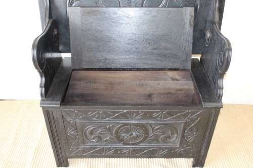A superb antique hand-carved blackened oak monks bench with a storage chest in the base