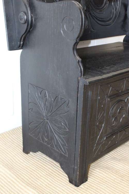 A superb antique hand-carved blackened oak monks bench with a storage chest in the base