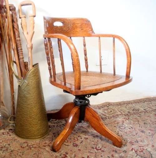 A superb antique oak captains swivel desk chair with a rattan seat in very good condition.