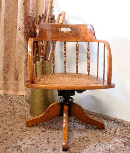 A superb antique oak captains swivel desk chair with a rattan seat in very good condition.