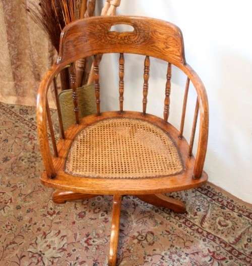 A superb antique oak captains swivel desk chair with a rattan seat in very good condition.