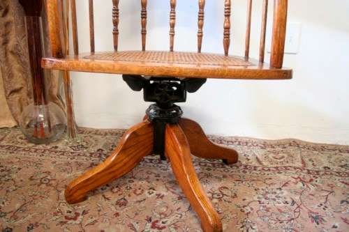 A superb antique oak captains swivel desk chair with a rattan seat in very good condition.