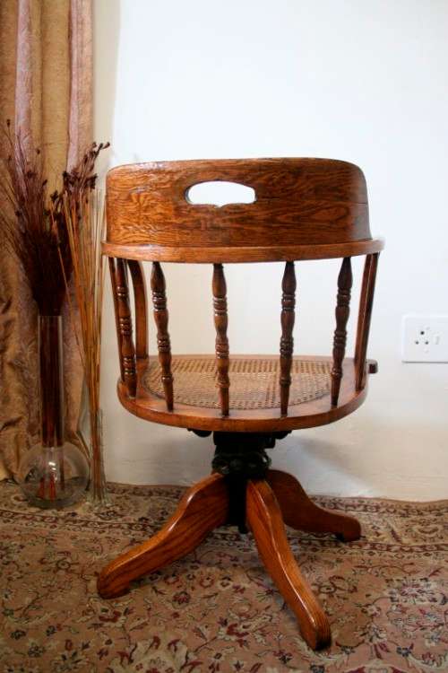 A superb antique oak captains swivel desk chair with a rattan seat in very good condition.