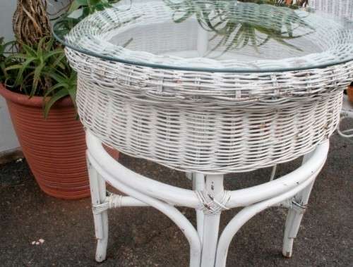 A wonderful white wicker table with a glass top and a chair all weather outdoor/ patio set.