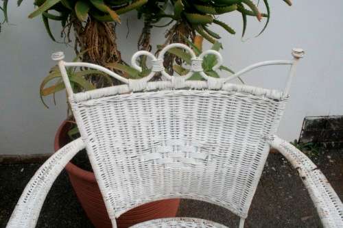 A wonderful white wicker table with a glass top and a chair all weather outdoor/ patio set.