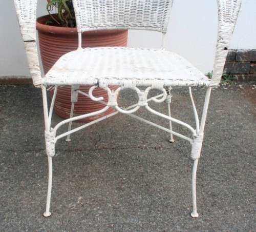 A wonderful white wicker table with a glass top and a chair all weather outdoor/ patio set.