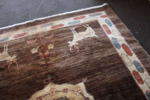 A stylish & unusual brown Iranian Meshkin Persian Carpet w/ deer motifs & centre medallion