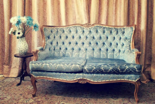 2 beautiful, elegant carved Victorian sofas with deep button detailing and blue period style fabric.
