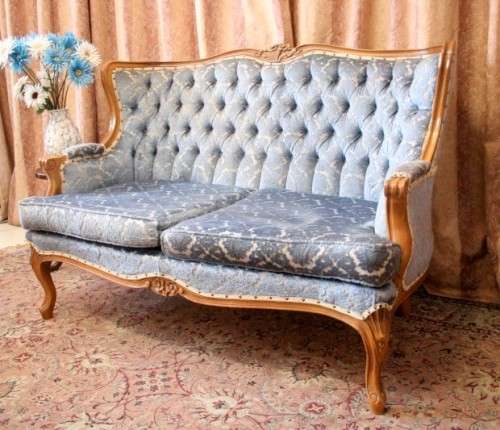 2 beautiful, elegant carved Victorian sofas with deep button detailing and blue period style fabric.