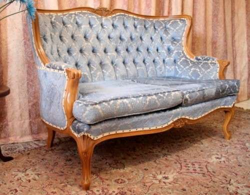 2 beautiful, elegant carved Victorian sofas with deep button detailing and blue period style fabric.