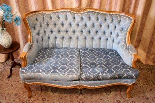 2 beautiful, elegant carved Victorian sofas with deep button detailing and blue period style fabric.