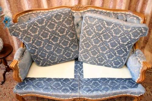 2 beautiful, elegant carved Victorian sofas with deep button detailing and blue period style fabric.