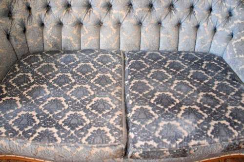 2 beautiful, elegant carved Victorian sofas with deep button detailing and blue period style fabric.