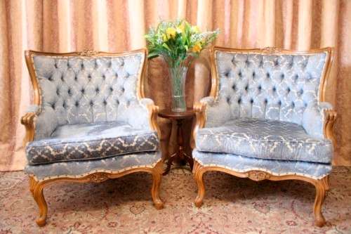 Two elegant hand carved Victorian arm chairs with deep button detailing & gorgeous blue fabric.
