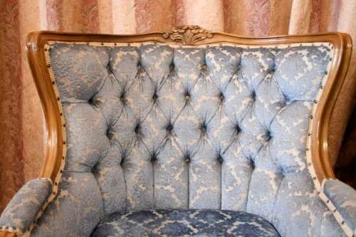 Two elegant hand carved Victorian arm chairs with deep button detailing & gorgeous blue fabric.