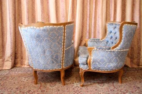 Two elegant hand carved Victorian arm chairs with deep button detailing & gorgeous blue fabric.