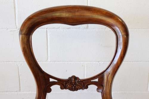 A beautifully upholstered antique Victorian solid mahogany carved balloon-back occasional chair