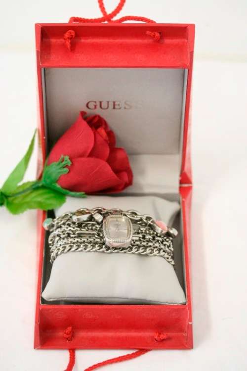 A stunning "GUESS" ladies wrist watch with patterned chains and coloured stone charms.
