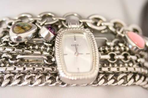 A stunning "GUESS" ladies wrist watch with patterned chains and coloured stone charms.