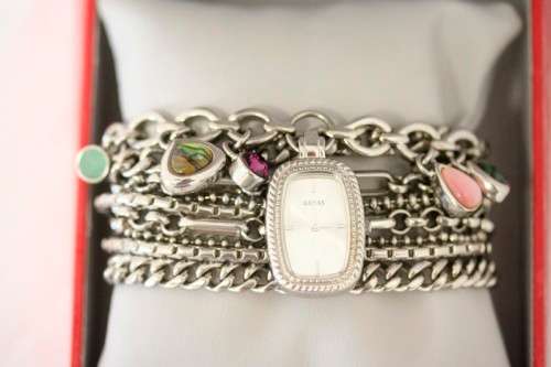 A stunning "GUESS" ladies wrist watch with patterned chains and coloured stone charms.
