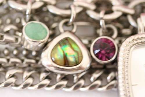 A stunning "GUESS" ladies wrist watch with patterned chains and coloured stone charms.