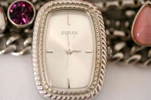 A stunning "GUESS" ladies wrist watch with patterned chains and coloured stone charms.