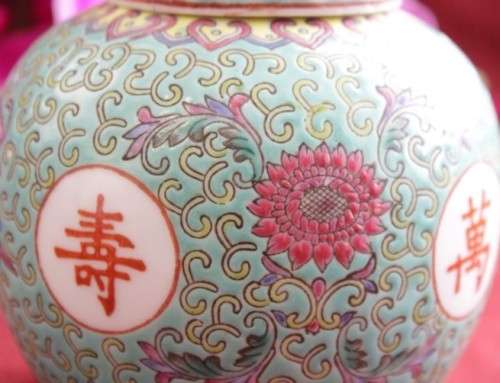 A beautiful and detailed jade-green oriental ginger jar & lid with hand painted symbols and flowers