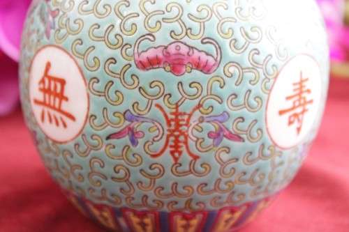 A beautiful and detailed jade-green oriental ginger jar & lid with hand painted symbols and flowers